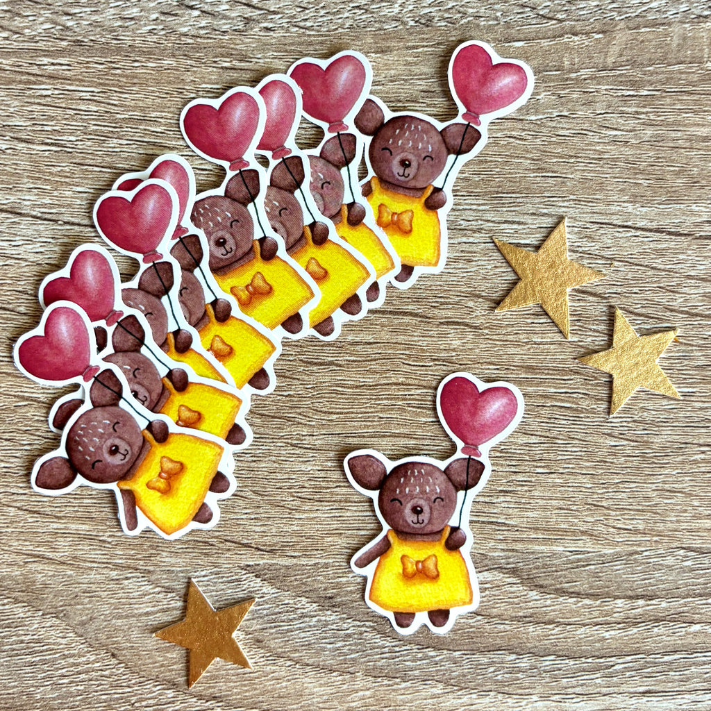 Sticker représentant une biche avec un ballon en forme de cœur et une robe jaune